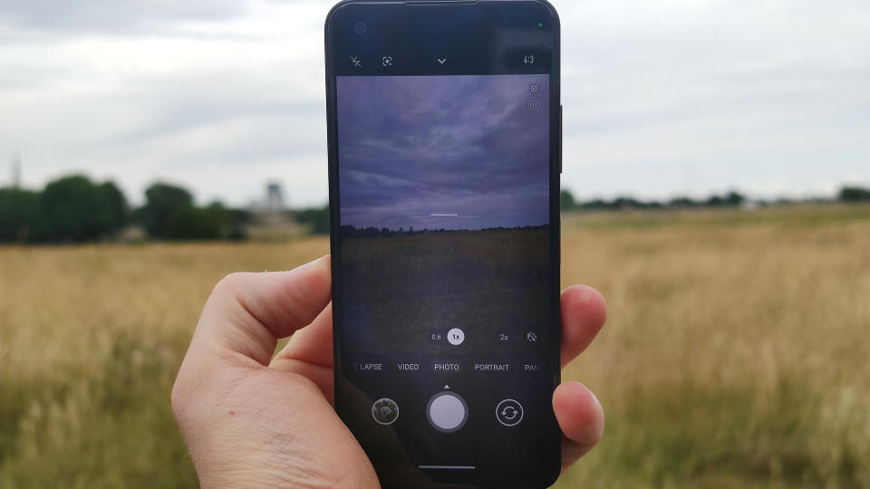 The Asus Zenfone 10 on a bench, with a field in the background