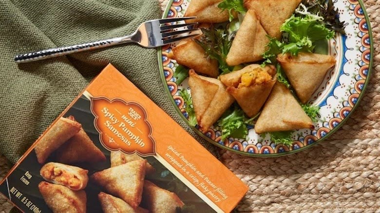 Pumpkin samosas on plate next to box 