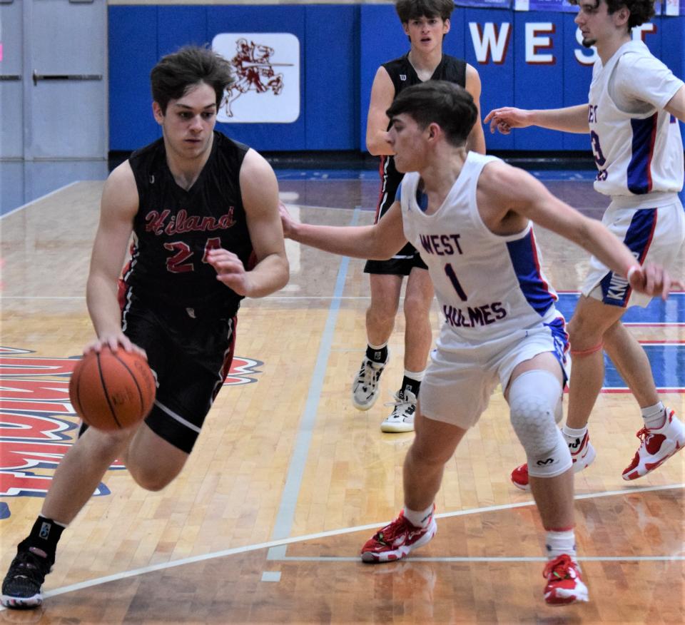 Hiland's Chris Shetler drives against Blake Morrison during the Hawks' 57-52 triumph over the Knights Tuesday at West Holmes.