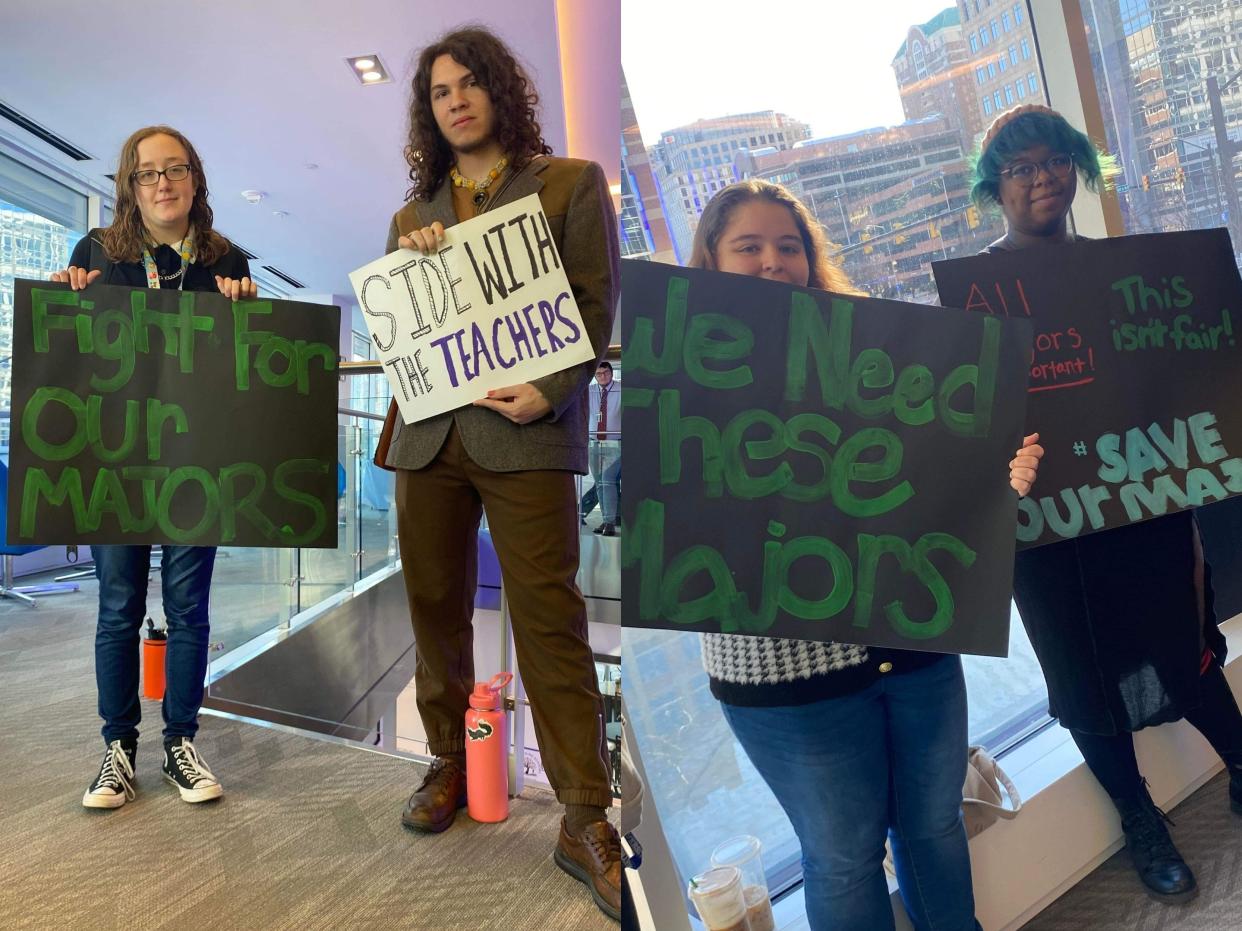 Four students holding signs that say "fight for our majors," "side with teachers." "we need these majors" and "save our majors."