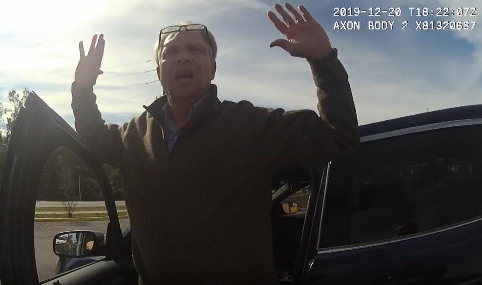 FBI Special Agent Alexis Hatten holds his hands up as Franklin County Deputy Rolf Gordon detains him during Dec. 20 incident in Carrabelle.