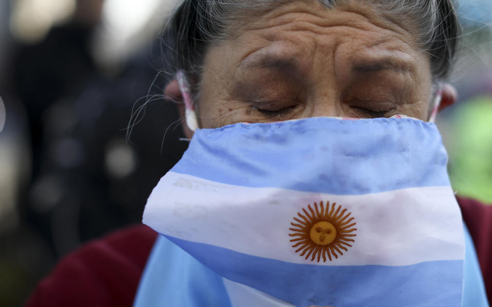 Una mujer usa una bandera de Argentina como cubrebocas durante una protesta para exigir al gobierno el fin de la larga cuarentena que impuso para enfrentar el nuevo coronavirus . La manifestación se realizó en Buenos Aires, el jueves 9 de julio de 2020. (AP Foto/Natacha Pisarenko)