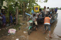 CORRECTS TO SAY EAST OF PHNOM PENH, NOT EASTERN - A coffin of Son Sophat, a teen victim of a boat accident, gets off from a wooden boat during a funeral procession in Koh Chamroeun village, east of Phnom Penh, Cambodia, Friday, Oct. 14, 2022. Multiple students in southern Cambodia who were crossing a river have died after the boat they were on capsized Thursday night, officials said. (AP Photo/Heng Sinith)