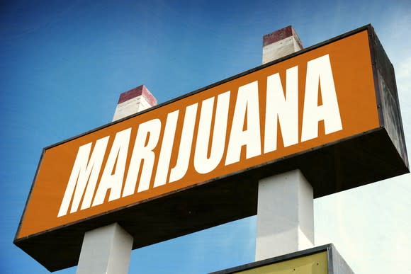 A large sign outside of a cannabis dispensary that reads in large white letters, Marijuana.