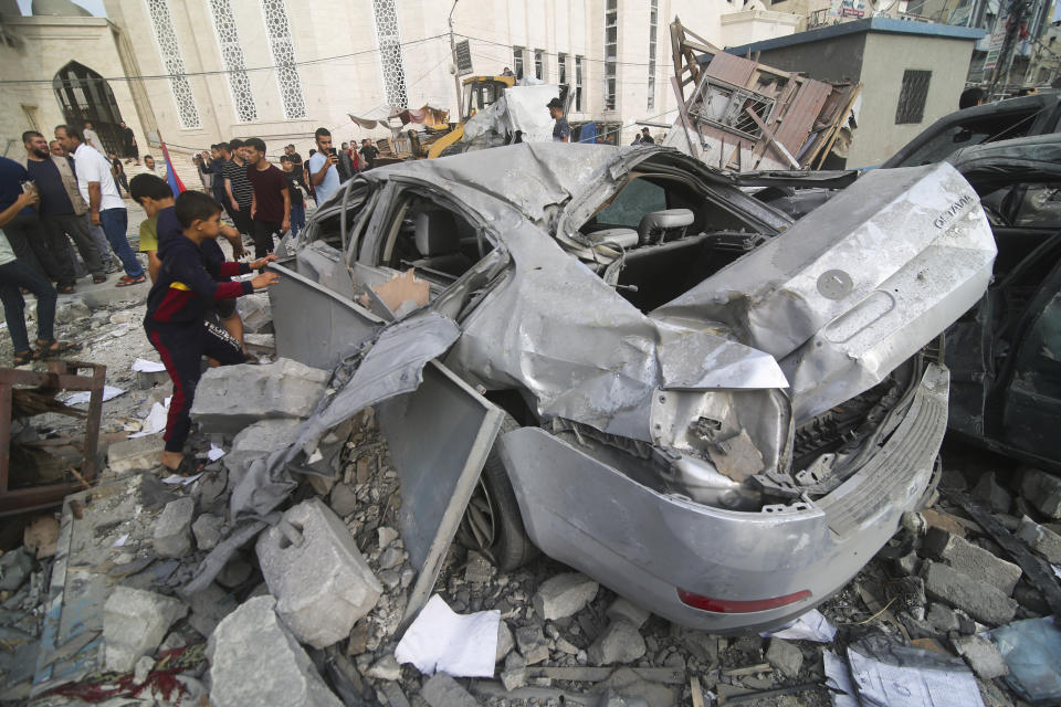 Palestinians inspect the damage of destroyed building after Israeli airstrikes in Khan Younis, Gaza Strip, Tuesday, Oct. 10, 2023. (AP Photo/Hatem Ali)