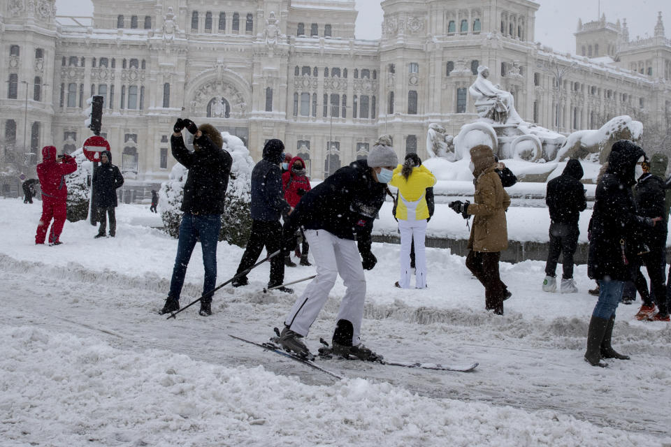 Una mujer esquía frente al monumento de Cibeles frente al Ayuntamiento durante una fuerte nevada en el centro de Madrid, el sábado 9 de enero de 2021. (AP Foto/Paul White)