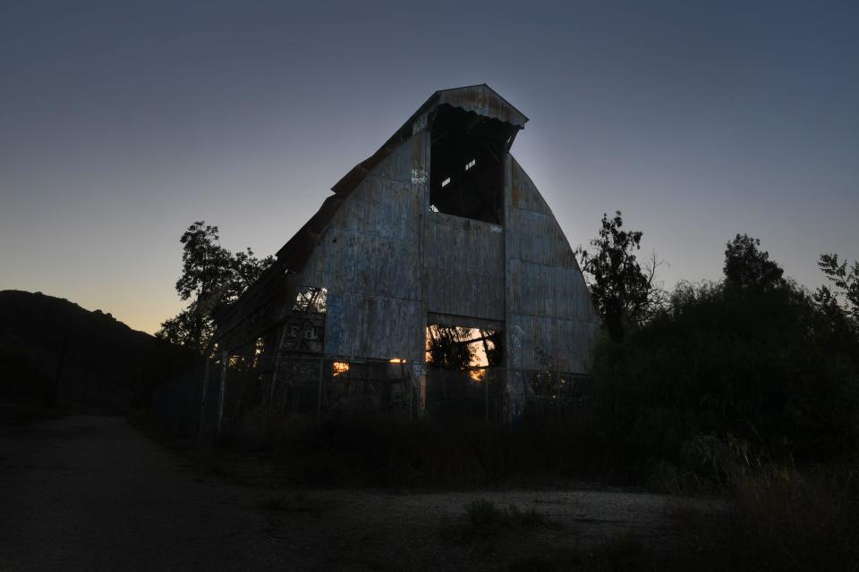 The sun sets behind a barn at Scary Dairy on Monday.