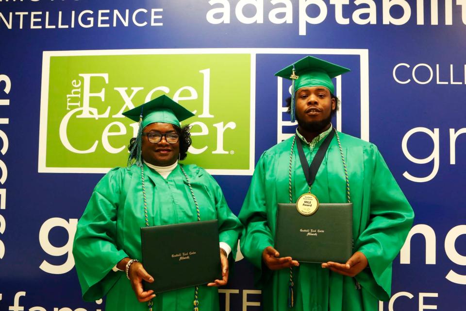 Recent graduates, Sandra Wicks, left, and Garrett Ferby, right, hold their diplomas in front of a mural inside of The Excel Center, on Monday, November 21, 2023, located at 2576 Thousands Oaks in Memphis, Tenn.