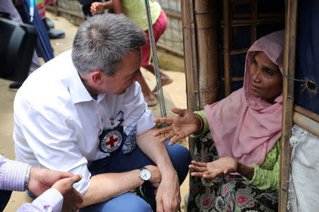 Peter Maurer, president of the International Committee of the Red Cross (ICRC), interacts with a Rohingya woman during his visit to a refugee camp in Cox's Bazar, Bangladesh, July 1, 2018. REUTERS/Mohammad Ponir Hossain