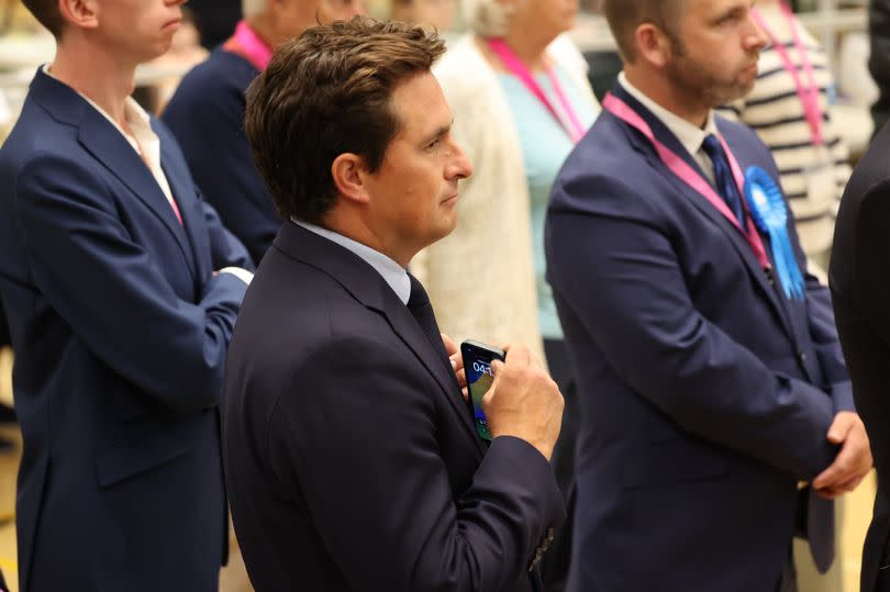 Johnny Mercer listens to Labour's Fred Thomas as he gives his victory speech