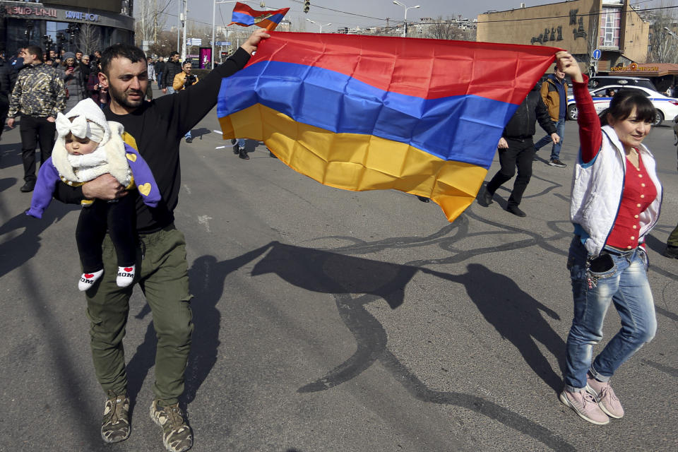 Supporters of Armenian Prime Minister Nikol Pashinyan march with Armenian national flags toward the main square in Yerevan, Armenia, Thursday, Feb. 25, 2021. Armenia's prime minister has spoken of an attempted military coup after facing the military's General Staff demand to step down. The developments come after months of protests sparked by the nation's defeat in the Nagorno-Karabakh conflict with Azerbaijan. (Stepan Poghosyan/PHOTOLURE via AP)