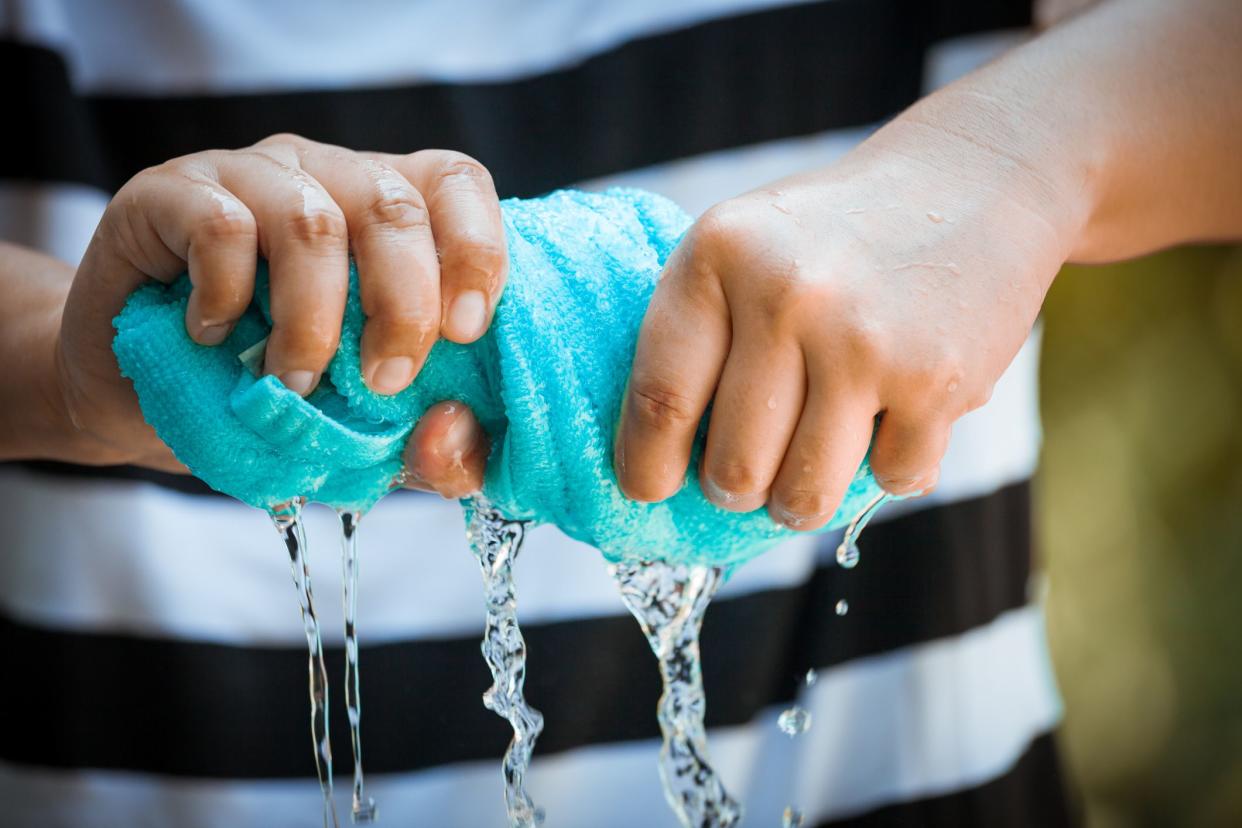 hands wringing out blue towel