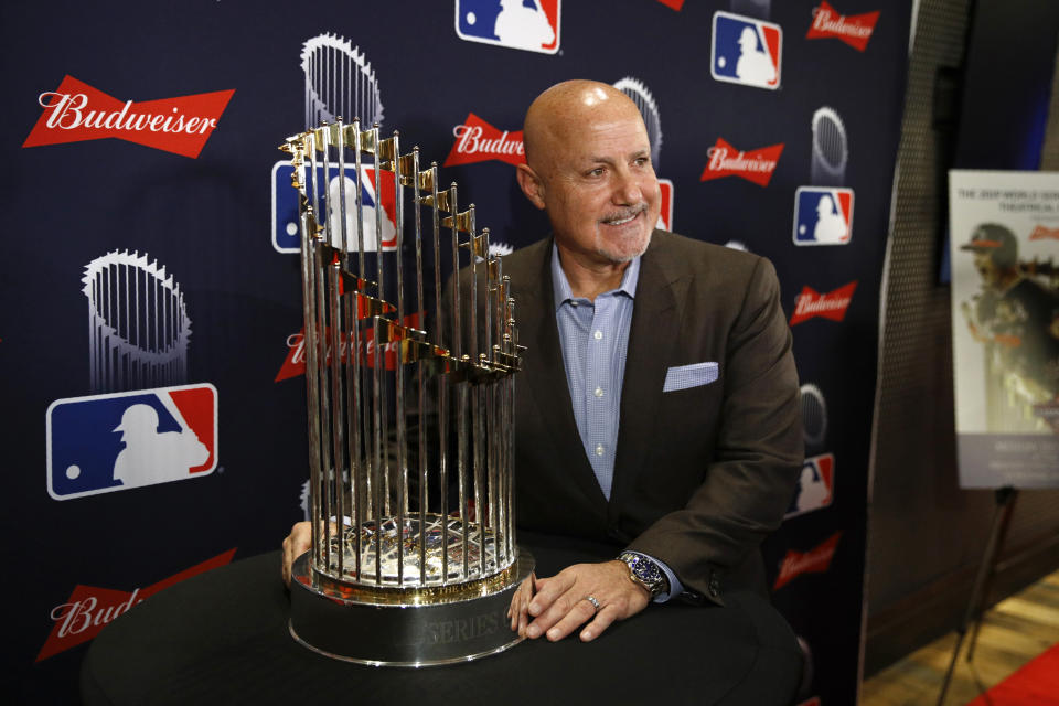 Washington Nationals general manager Mike Rizzo poses with the World Series trophy as he arrives for the premiere of a documentary film on the team's first World Series baseball championship, Monday, Dec. 2, 2019, in Washington. (AP Photo/Patrick Semansky)
