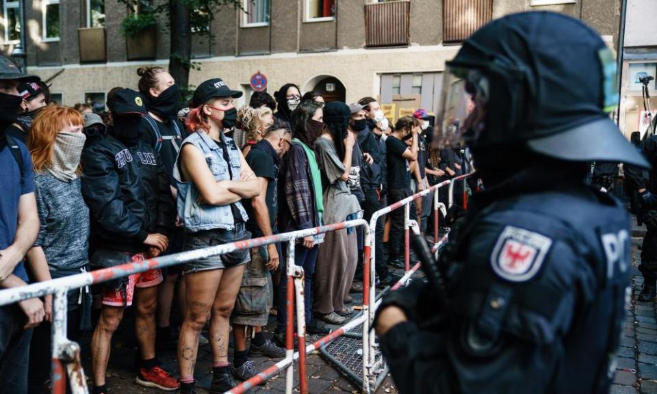 Demonstrators stand in front of a police line during the seizure of the bar