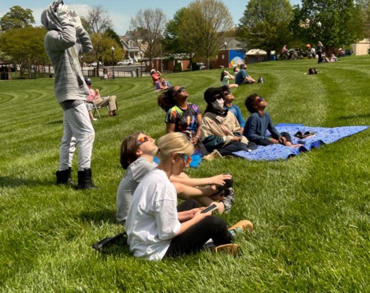 Photo is of when the peak partial solar eclipse hit and everyone was gazing at the sun with their glasses, mesmerized by this exciting moment.