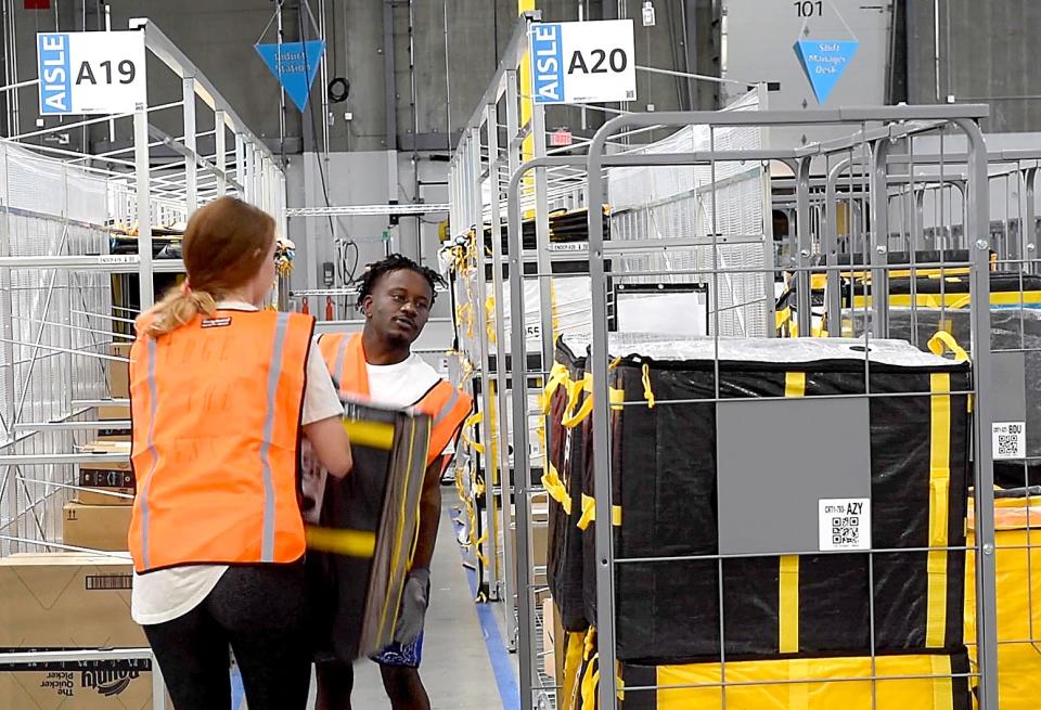 Amazon station workers load carts with packages to be shipped in the central Missouri area from the new Amazon station at the Cartwright Business and Technology Park near the Columbia Regional Airport on Thursday.
