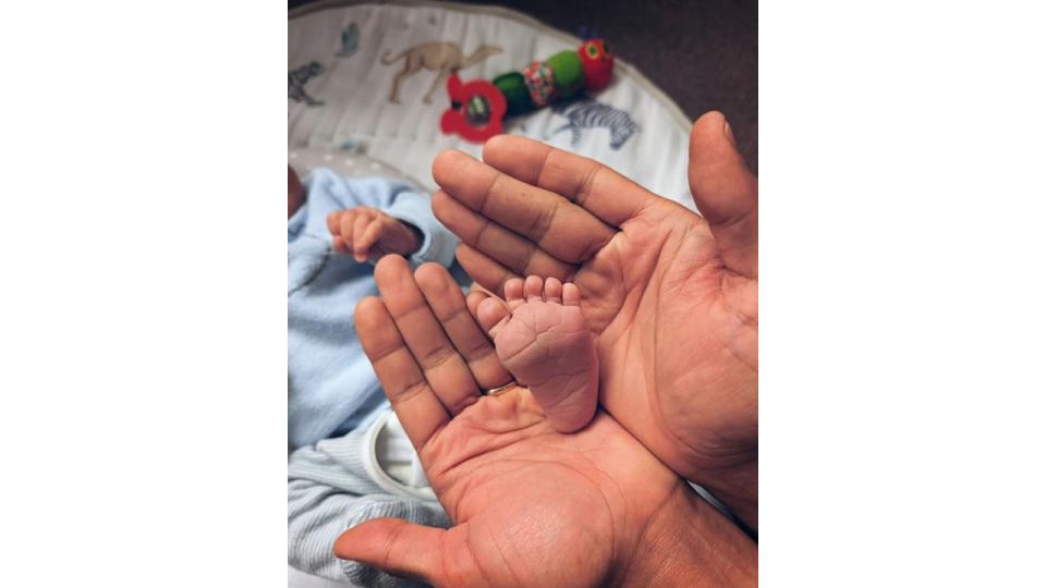 father holding newborn's foot 