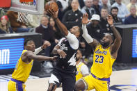 Los Angeles Clippers guard Norman Powell, center, shoots as Los Angeles Lakers forward Rui Hachimura, left, and forward LeBron James defend during the first half of an NBA basketball game Wednesday, Feb. 28, 2024, in Los Angeles. (AP Photo/Mark J. Terrill)