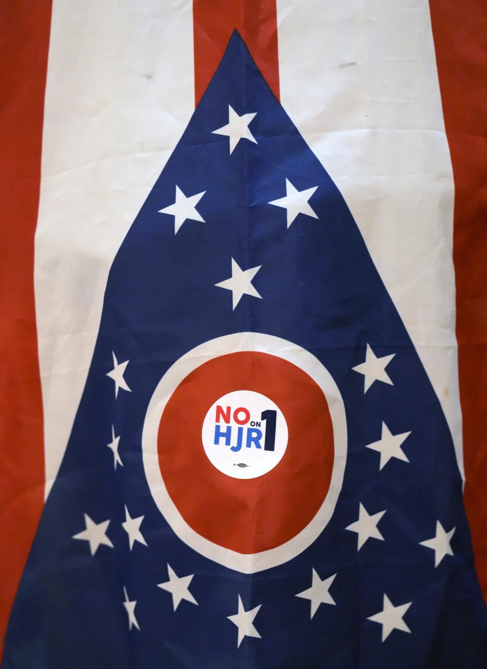 A demonstrator wears an Ohio flag in the rotunda of the Ohio Statehouse on Wednesday to protest HJR 1/SJR 2, which would require a 60% vote to approve constitutional amendments.