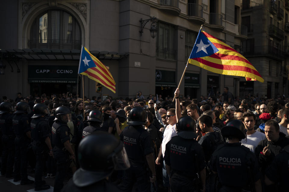 Catalan police officers cordon off the street to stop pro independence demonstrators, on their way to meet demonstrations by members and supporters of National Police and Guardia Civil in Barcelona, Spain, Saturday, Sept. 29, 2018. (AP Photo/Felipe Dana)