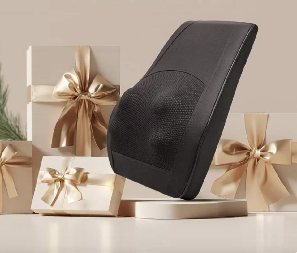 Black ergonomic lumbar support pillow displayed with gift boxes. Ideal for office chair upgrade