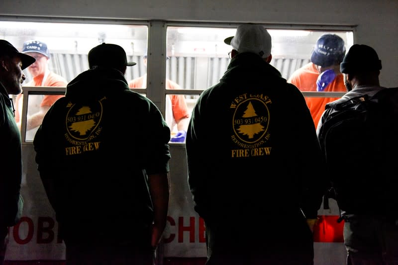 Firemen get dinner at the Cal Fire basecamp Mobile Kitchen Unit after a shift fighting the Kincaid Fire in Santa Rosa