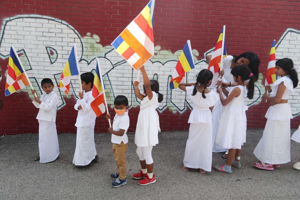 Children prepare to march with their Buddhist flags before the dedication ceremony in Akron.