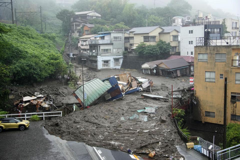 Houses are damaged by mudslide following heavy rain at Izusan district in Atami, west of Tokyo, Saturday, July 3, 2021. A powerful mudslide carrying a deluge of black water and debris crashed into rows of houses in a town west of Tokyo following heavy rains on Saturday, leaving multiple people missing, officials said. (Naoya Osato/Kyodo News via AP)