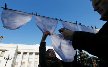Anti-corruption activists hang underwear during a rally demanding officials register their income declarations in the e-declaration system in front of the Ukrainian parliament building in Kiev, Ukraine, October 18, 2016. REUTERS/Valentyn Ogirenko