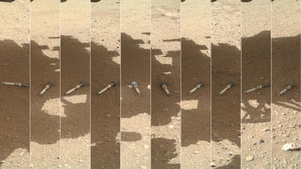 silver metal tubes lying on reddish-orange dust and rocks