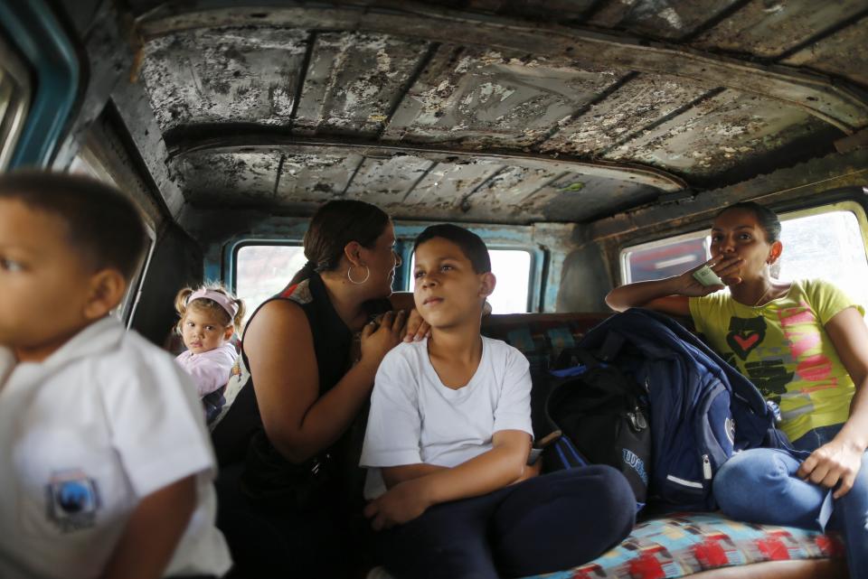 Passengers ride on public transport in Caracas, Venezuela, Wednesday, Feb. 19, 2020. The debate over fresh U.S. sanctions aimed at forcing out Venezuela's Nicolás Maduro played out Wednesday across the crisis-stricken South American nation. Families have been split up with at least 4.5 million Venezuelans fleeing crumbling public services. (AP Photo/Ariana Cubillos)