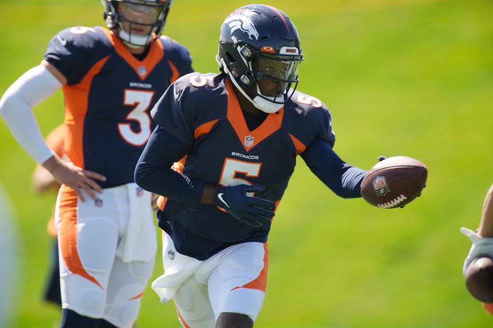 Denver Broncos quarterback Teddy Bridgewater, front, takes part in drills as quarterback Drew Lock looks on during NFL football practice at the team's headquarters Wednesday, Aug. 25, 2021, in Englewood, Colo.