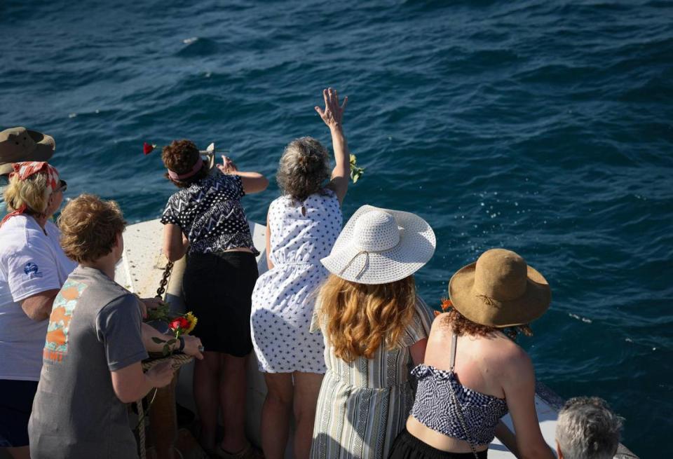 The family of Barbara Ann Buchele Voorstad and Henri Theodor Voorstad toss flowers into the water after a reef ball containing their ashes was lowered into the water.