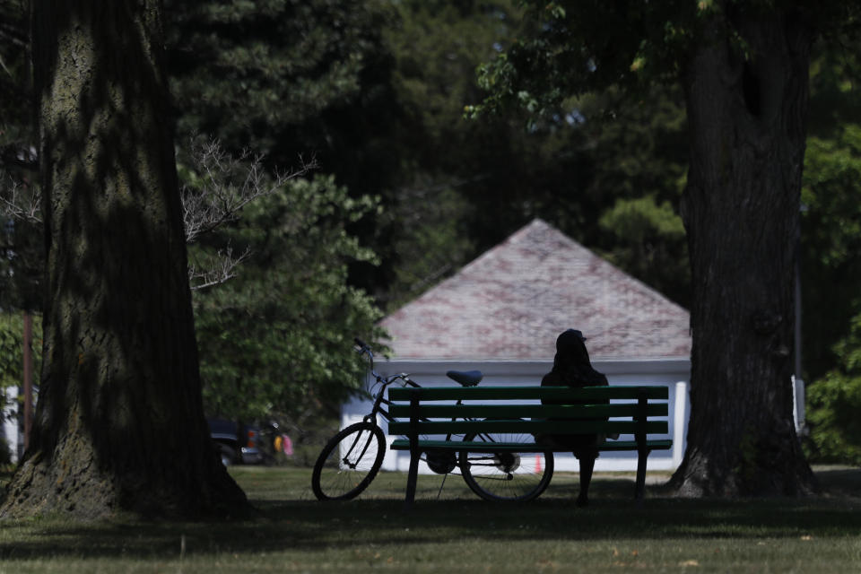 A cyclist sits on a Hoyt Park bench Monday, June 29, 2020, in Saginaw, Mich. The county is majority-white and one-fifth the population is Black. (AP Photo/Charles Rex Arbogast)