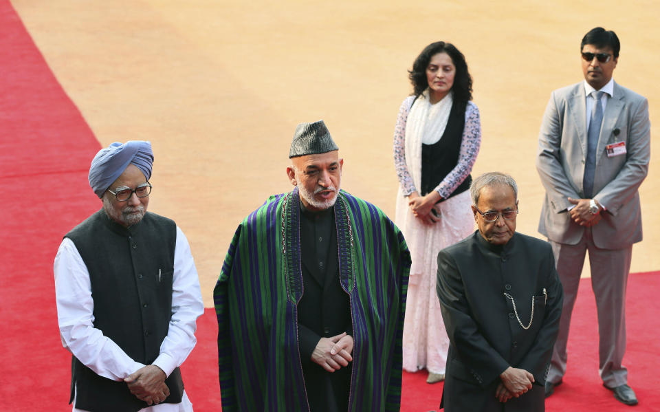 Afghanistan’s President Hamid Karzai, center, stands with Indian Prime Minister Manmohan Singh, left, and President Pranab Mukherjee during a ceremonial reception at the Presidential Palace in New Delhi, India, Monday, Nov. 12, 2012. Karzai is on a four-day official visit to India. (AP Photo/Manish Swarup)