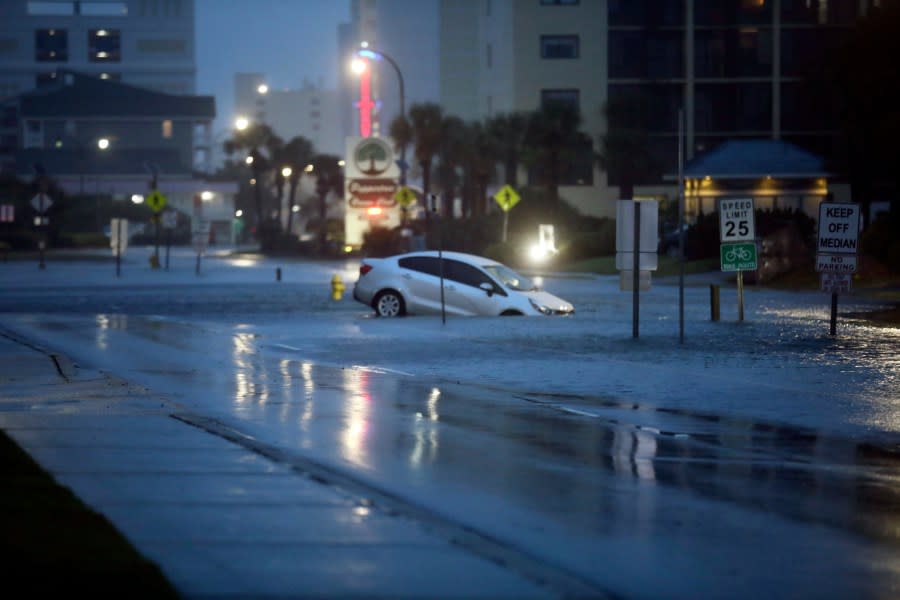 A car plunged into flood waters on Ocean Boulevard in North Myrtle Beach on Wednesday, Aug. 30, 2023 after the passage of Hurricane Idalia. (Jason Lee/The Sun News via AP)