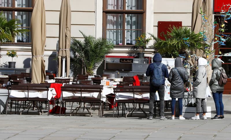 People stand next to a cafe in Vienna