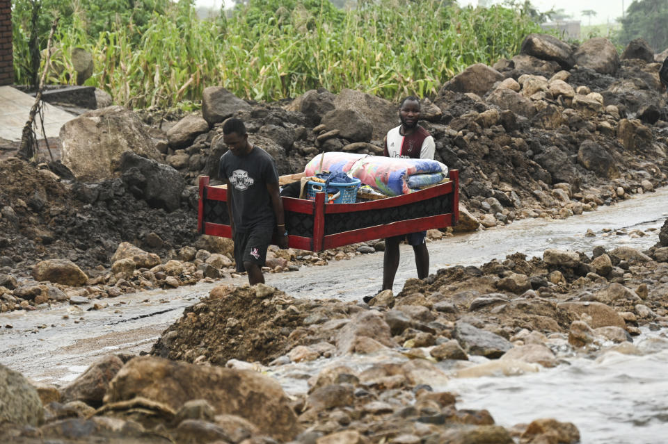 Men transport their salvaged belongings in Chiradzulu, southern Malawi, Friday March 17, 2023. Authorities are still getting to grips with the scale of Cyclone Freddy's destruction in Malawi and Mozambique since late Saturday, with over 300 people confirmed dead and several hundreds still displaced or missing. (AP Photo/Thoko Chikondi)