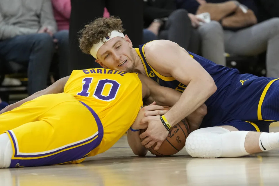 Los Angeles Lakers guard Max Christie (10) wrestles for the ball with Golden State Warriors guard Brandin Podziemski during the first half of an NBA basketball game in San Francisco, Thursday, Feb. 22, 2024. (AP Photo/Jeff Chiu)