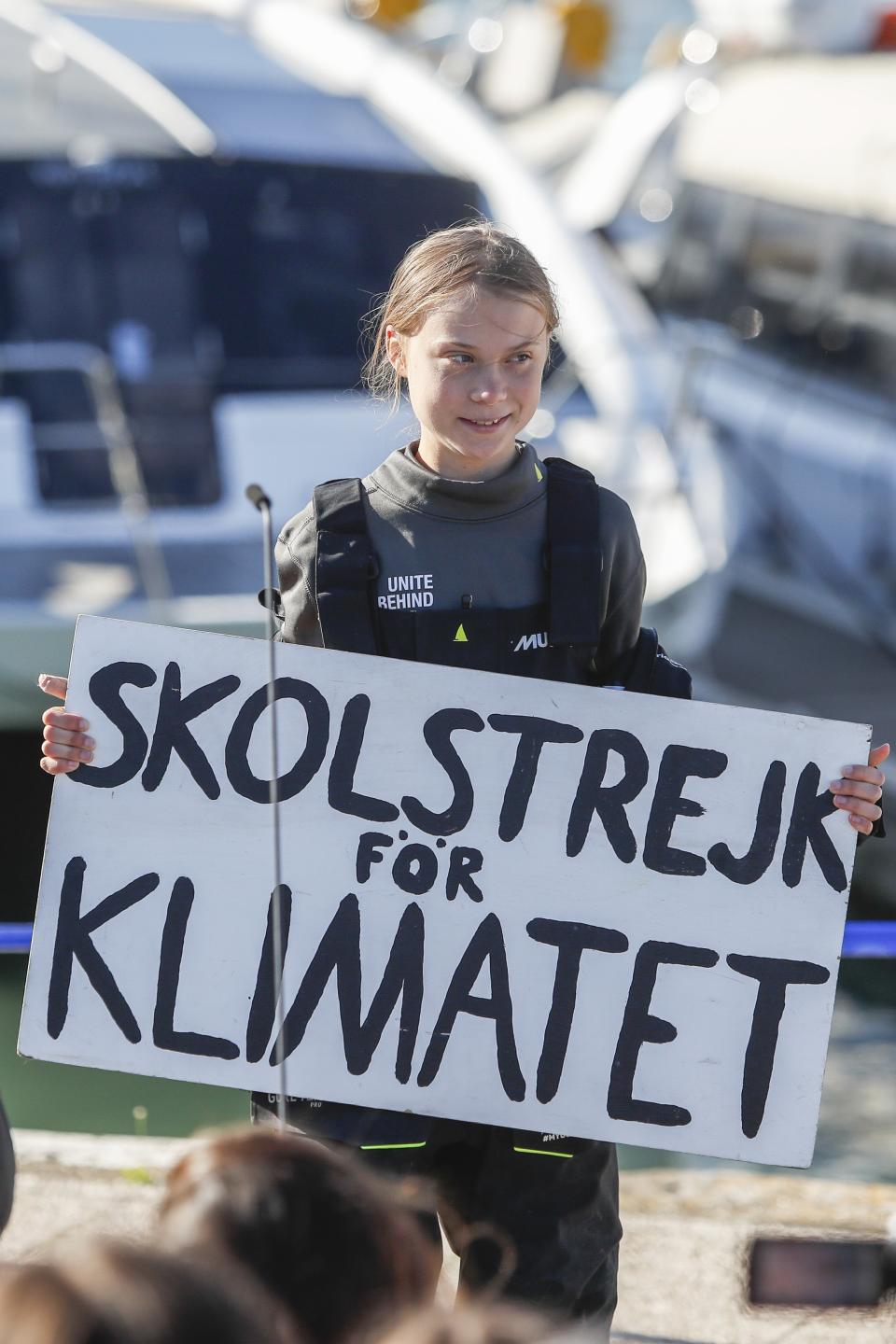 Climate activist Greta Thunberg holds a "Fridays for Future" banner in Lisbon, Tuesday, Dec 3, 2019. Thunberg has arrived by catamaran in the port of Lisbon after a three-week voyage across the Atlantic Ocean from the United States. The Swedish teen sailed to the Portuguese capital before heading to neighboring Spain to attend the U.N. Climate Change Conference taking place in Madrid. The banner reads in Swedish " school strike for the climate". (AP Photo/Armando Franca)