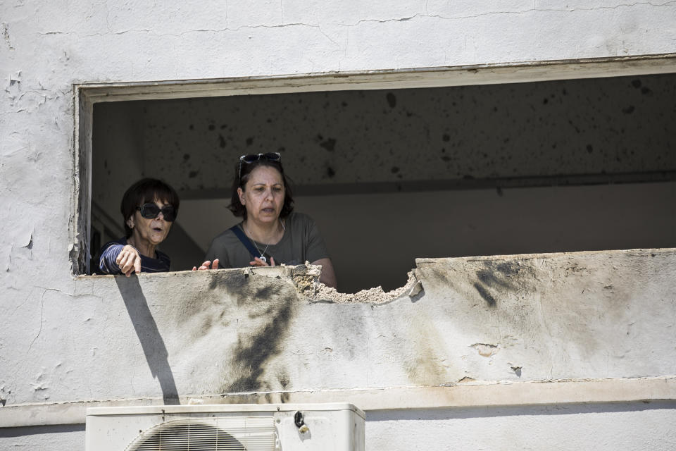 Women look at the damage caused by a rocket fired from Gaza that hit a house in a moshav in Israel near the border with Gaza, Saturday, May 4, 2019. Palestinian militants in the Gaza Strip fired at least 90 rockets into southern Israel on Saturday, according to the Israeli military, triggering retaliatory airstrikes and tank fire against militant targets in the blockaded enclave and shattering a month-long lull in violence. (AP Photo/Tsafrir Abayov)