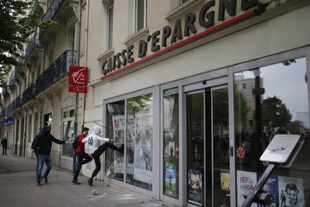 Youths break a bank window during a demonstration to protest the the government's proposed labor law reforms in Nantes, France, May 26, 2016. REUTERS/Stephane Mahe