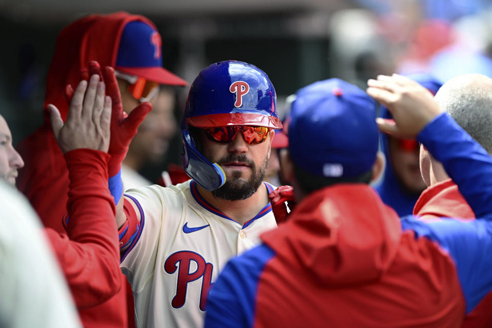 Philadelphia Phillies' Kyle Schwarber is greeted in the dugout after his solo home run off Atlanta Braves starting pitcher Chris Sale during the first inning of a baseball game Sunday, March 31, 2024, in Philadelphia. (AP Photo/Derik Hamilton)