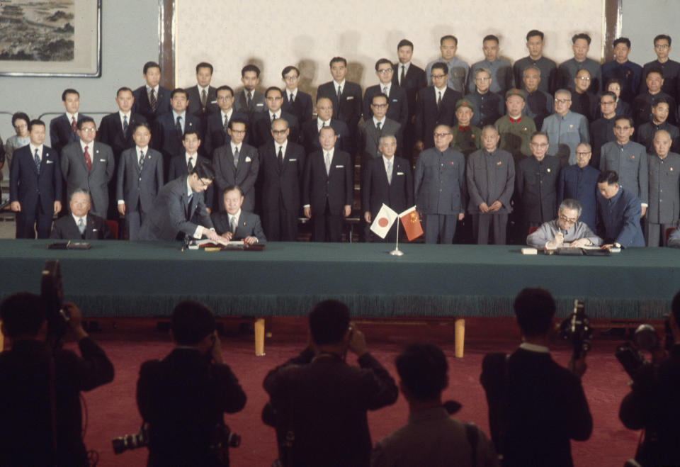 FILE - Japanese Prime Minister Kakuei Tanaka, sitting at center left, with Foreign Minister Masayoshi Ohira, far left, and Chinese Premier Zhou Enlai, sitting at right, sign the joint statement to normalize relations between the countries in Beijing on Sept. 29, 1972. Japan and China on Thursday, Sept. 29, 2022, mark the 50th anniversary of the 1972 normalization of their ties, but there isn't much of a celebratory mood. (AP Photo, File)