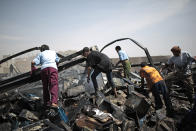 Workers salvage oil canisters from the wreckage of a vehicle oil store hit by Saudi-led airstrikes in Sanaa, Yemen, Thursday, July 2, 2020. (AP Photo/Hani Mohammed)