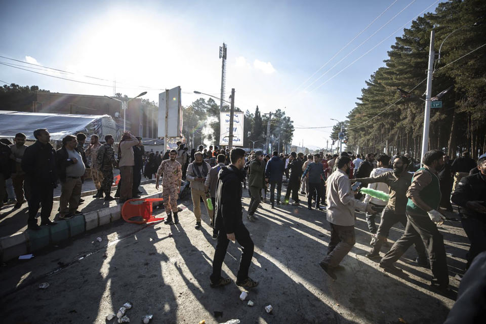 ADDS SOURCE - People look on after an explosion in Kerman, Iran, Wednesday, Jan. 3, 2024. Iran says the deadly twin bomb blasts occurred at an event honoring a prominent Iranian general slain in a U.S. airstrike in 2020. (Mahdi Karbakhsh Ravari/Mehr News Agnecy via AP)