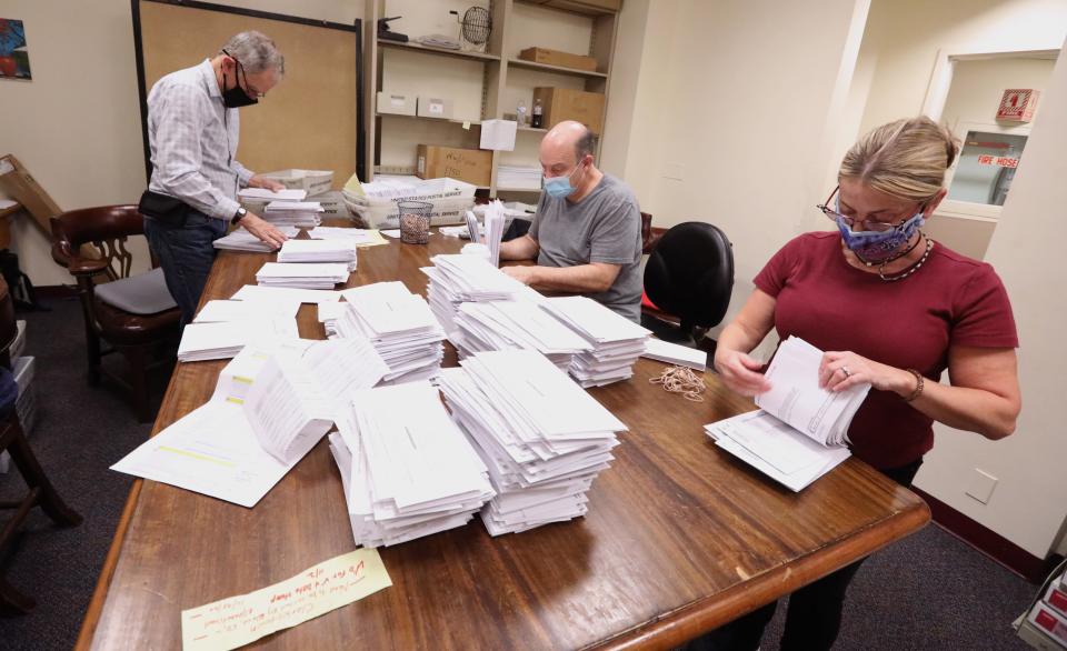 Michael Andrea, left, Vincent Pamtuso and Jeanette Lorence sort absentee ballots at the Rockland Board of Elections in New City Nov. 4, 2020.