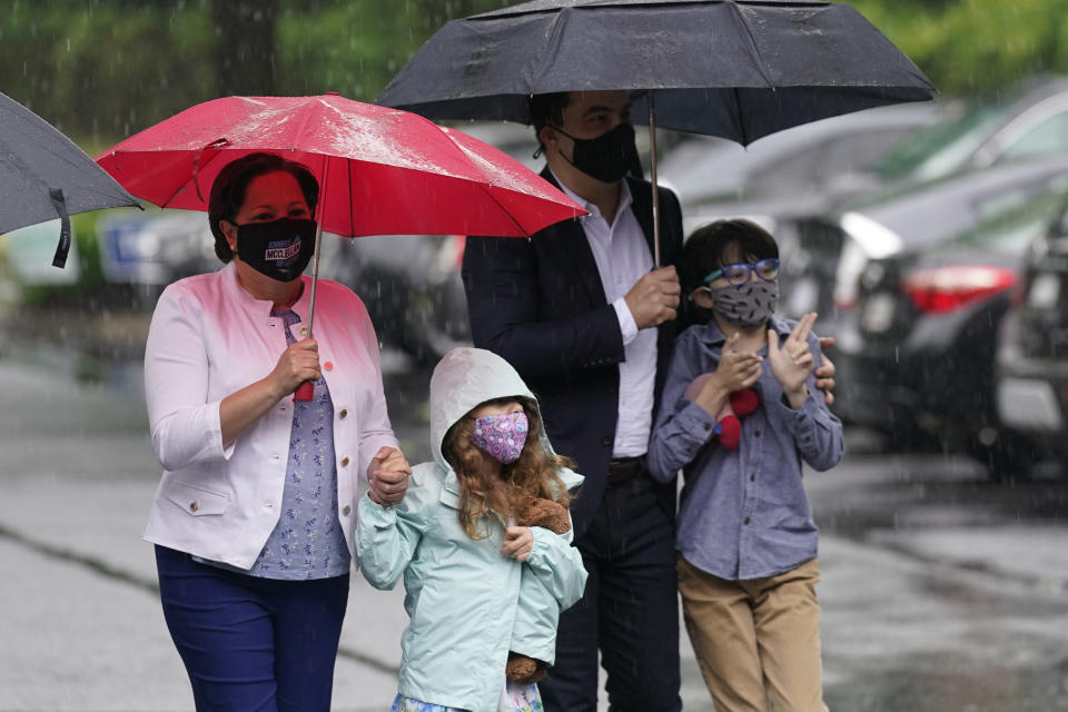 Democratic gubernatorial candidate, Virginia State Sen. Jennifer McClellan, left, arrives with her family, Samantha Mille, second from left, husband, Dave Mills and son Jackson Mills, right, at an early voting location in Richmond, Va., Saturday, May 29, 2021. McClellan faces four other Democrats in the primary. (AP Photo/Steve Helber)