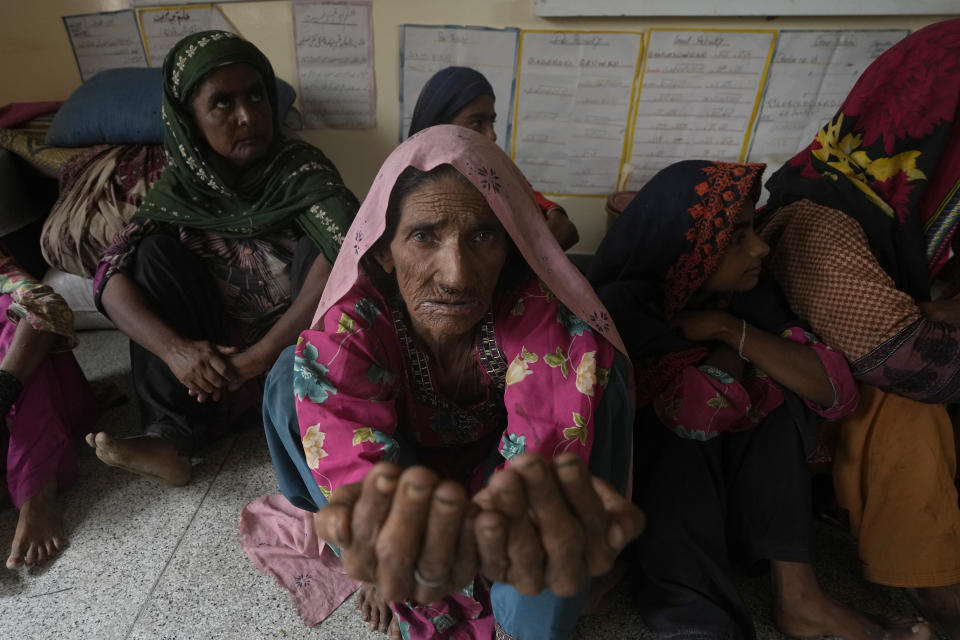 A woman prays as she with other families takes shelter in a school after fleeing from their villages of costal areas due to Cyclone Biparjoy approaching, in Gharo near Thatta, a Pakistan's southern district in the Sindh province, Wednesday, June 14, 2023. In Pakistan, despite strong winds and rain, authorities said people from vulnerable areas have been moved to safer places in southern Pakistan's districts. With Cyclone Biparjoy expected to make landfall Thursday evening, coastal regions of India and Pakistan are on high alert. (AP Photo/Fareed Khan)