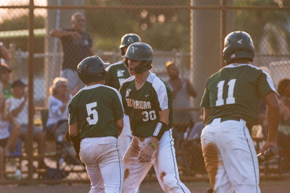 Jupiter third baseman Jake Finnegan (30) celebrates scoring alongside teammate Jupiter infielder Eddie Otero (5) during the District 11-7A championship baseball game between host Jupiter and Palm Beach Central on Thursday, May 4, 2023, in Jupiter, Fla. Final score, Jupiter, 11, Palm Beach Central, 3.